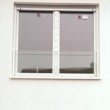 Zwei Fenster im oberen und unteren Bereich einer weißen Wand, darunter eine große Glastür.